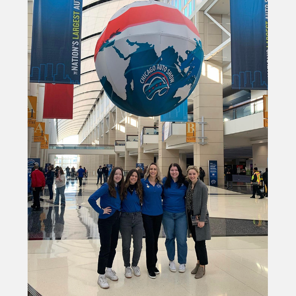 Students standing under large hanging globe