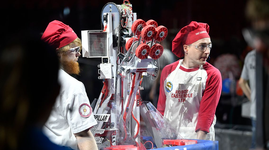 Two students carry a robot