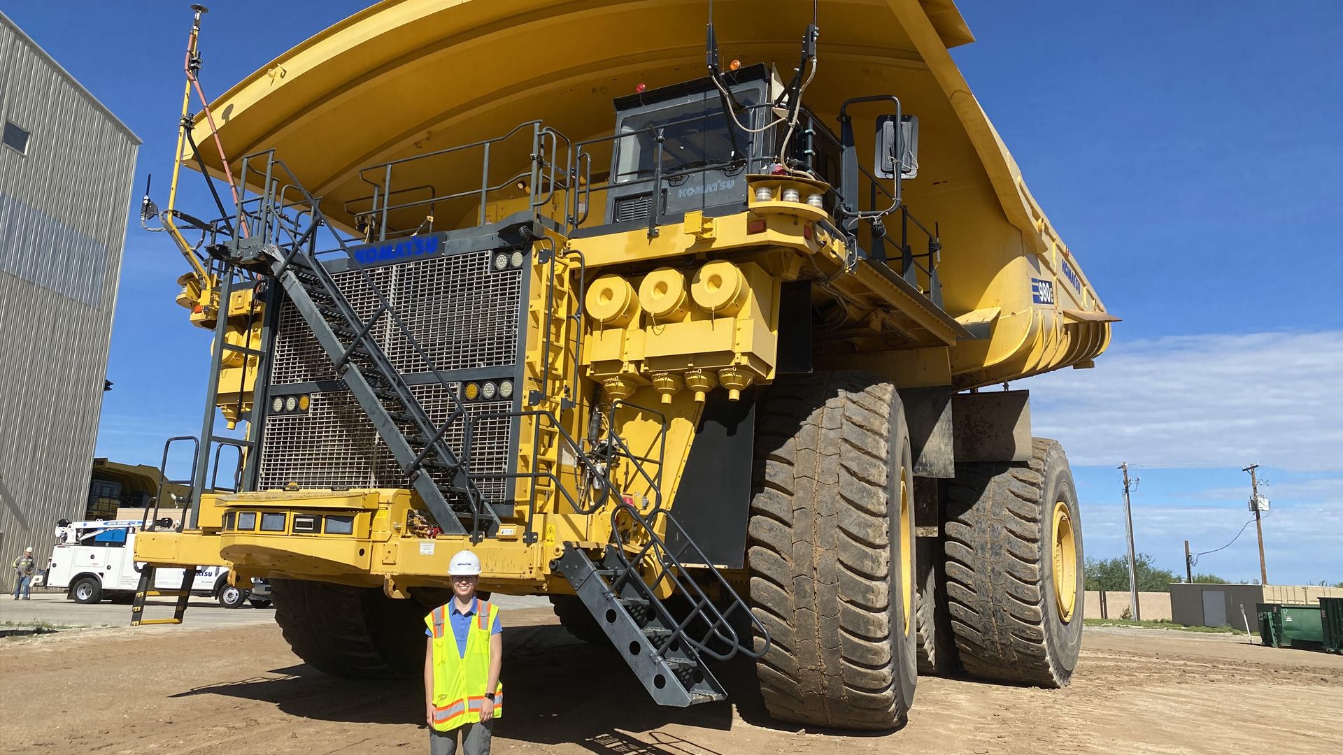 Jordan Tatgenhorst standing in front of a Komatsu dump truck.