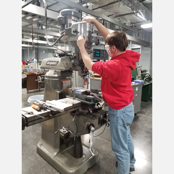 Bradley student creating parts in a machine shop for the robot.