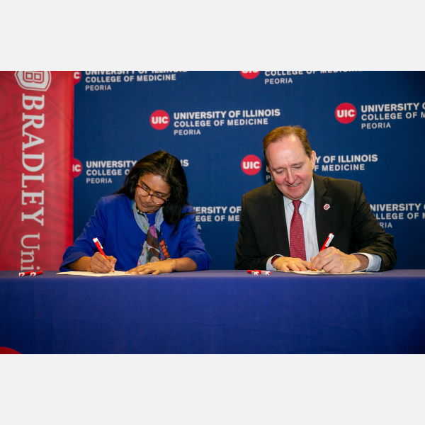 Regional Dean of UICOMP, Dr. Meenakshy Aiyer and Bradley University President Stephen Standifird sign the EAP agreement.
