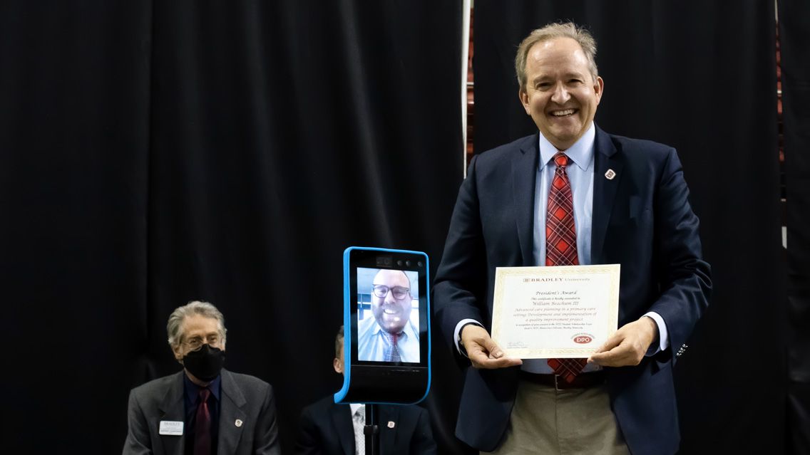 Bradley University President Dr. Stephen Standifird presenting Wil Beachum the President’s Award at the 2022 Student Scholarship Expo.