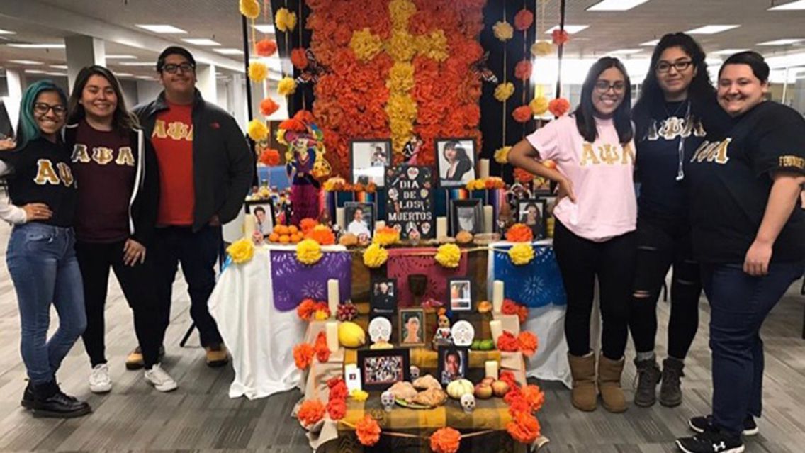 Dia de los muertos display with members from Alpha Psi Lambda.
