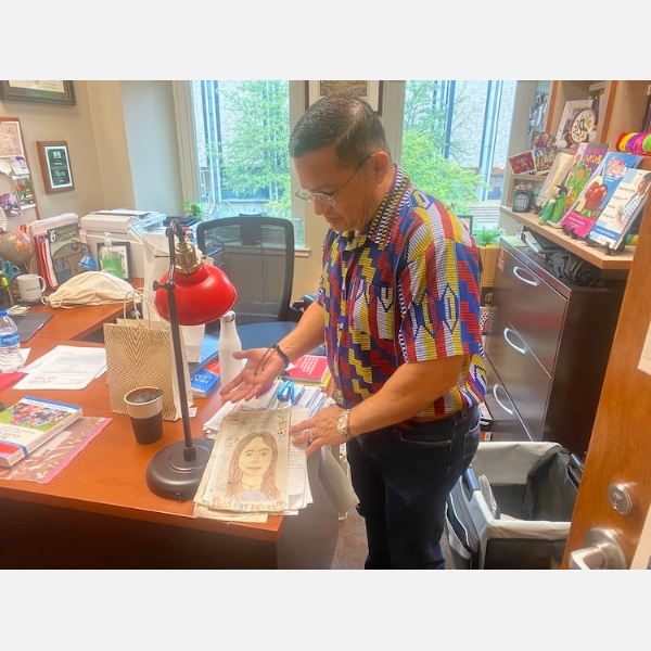 Dr. Juan Rios Vega flips through some of the self portraits from the final project for his ETE 280 course.
